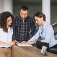 People reviewing documents at counter People reviewing documents at counter